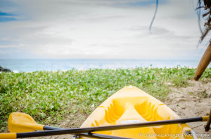 The photo shows the forward half of a kayak pointing to the sea in the distance.